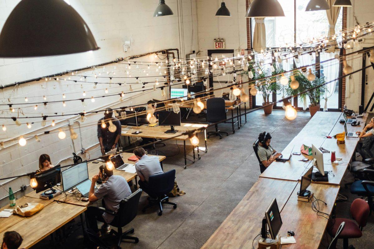 Desk Sharing. Auf diesem Foto wird ein Coworking Space abgebildet mit unpersonalisierten Schreibtischen, die man buchen muss.